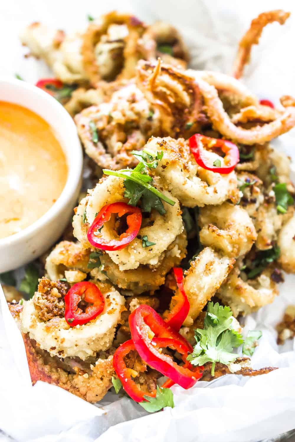 Keto Calamari in a tray with sliced peppers and a dipping sauce