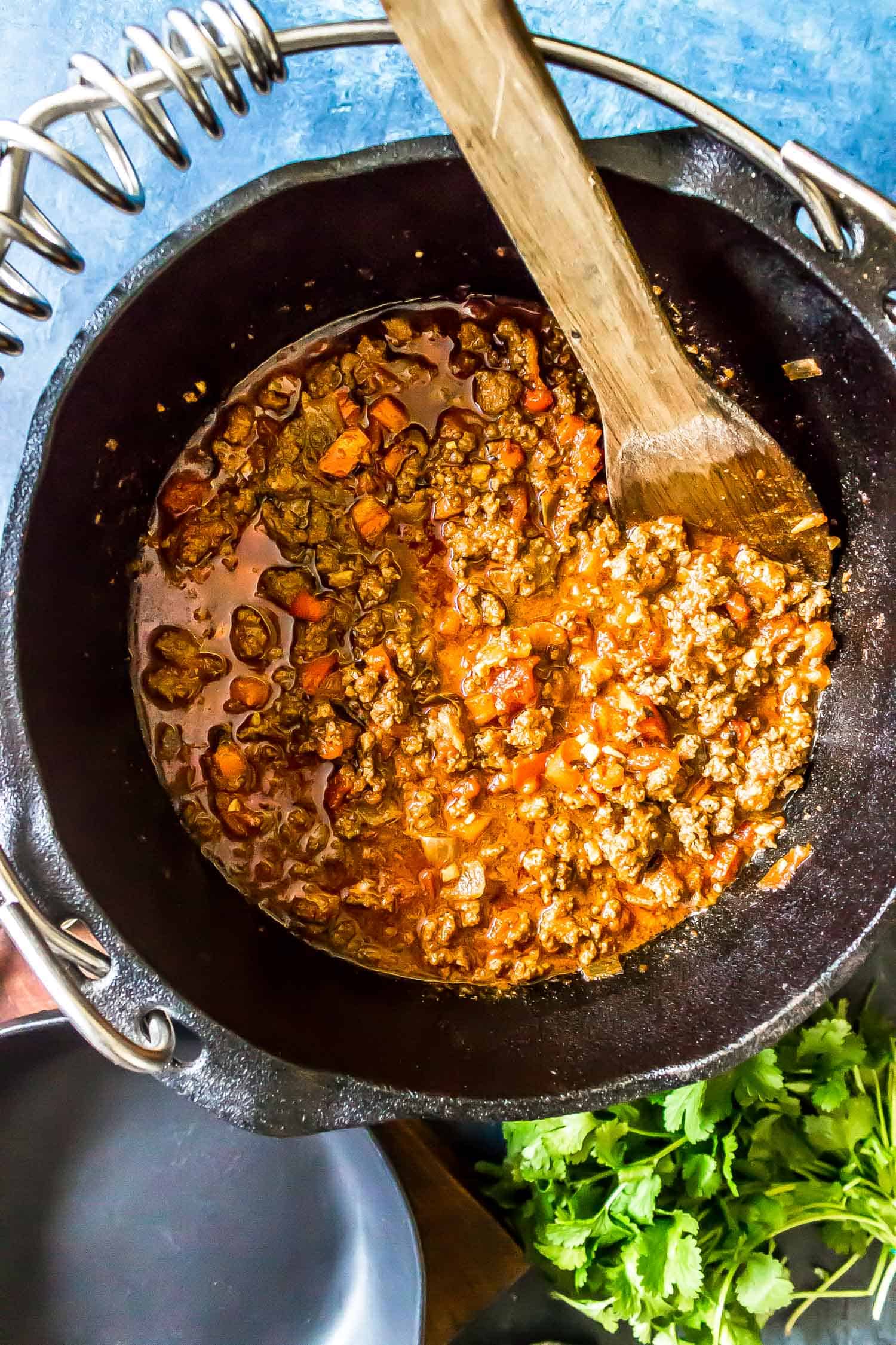 Keto Chili in Dutch oven with wooden spoon