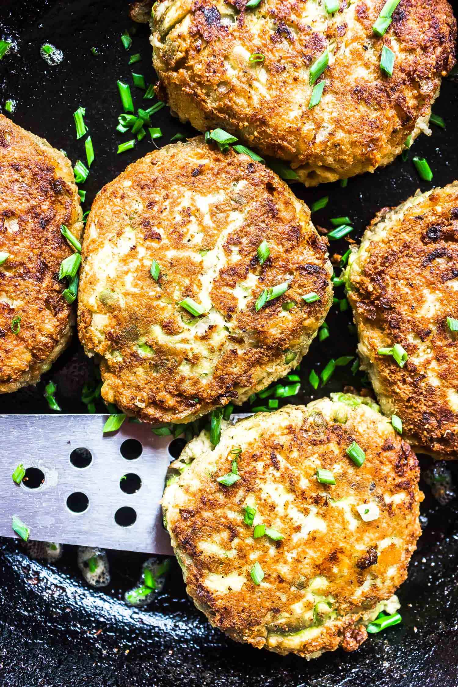 Keto Salmon Patties cooked in skillet with chives on top