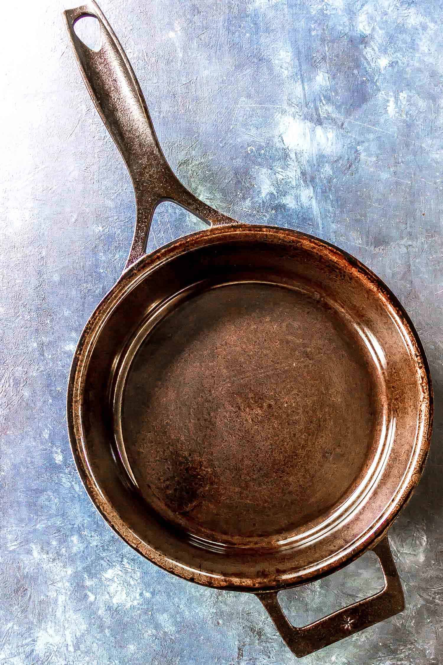 cast iron skillet sitting on a blue background